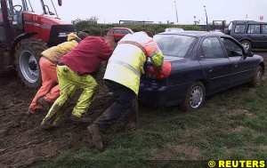 Volunteers help push cars from waterlogged carpark